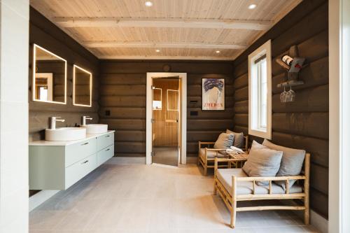 奥勒Åre Valley Lodges - Grand Ski Lodge的浴室设有木墙、水槽和椅子
