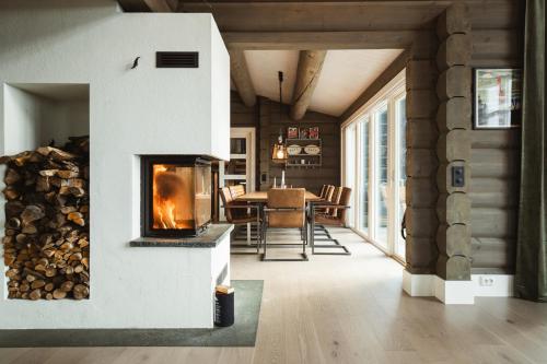 奥勒Åre Valley Lodges - Grand Ski Lodge的带壁炉的客厅和用餐室