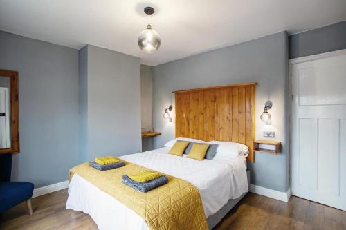 利兹Stylish and cosy cottage in the heart of Yorkshire的一间卧室配有一张带黄色毯子的大床