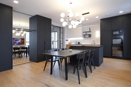 利贝雷茨Apartmány Vila Terasy的厨房以及带黑色桌椅的用餐室。