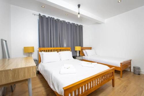 吉林汉姆Modern and Luxury House for 8的一间卧室配有两张床和一张书桌