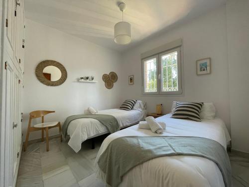 塞维利亚El Jardin de la Palmera的白色墙壁客房的两张床