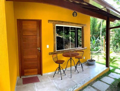 萨纳Segredo da alma的黄色的房子,庭院里设有两把椅子和一张桌子