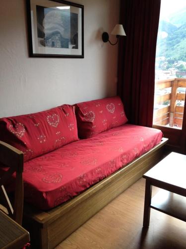 瓦卢瓦尔Les Chalets Valoria - 2 Pièces pour 4 Personnes 44的窗户房间里一张红色的沙发