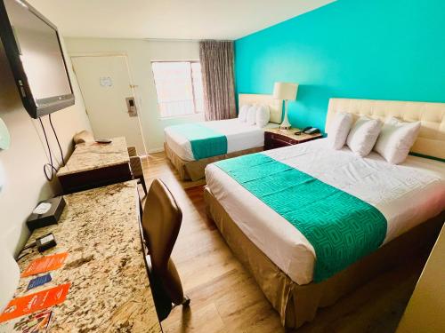 里诺Howard Johnson by Wyndham Downtown Reno的酒店客房设有两张床和一台平面电视。
