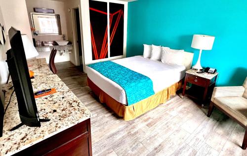 里诺Howard Johnson by Wyndham Downtown Reno的酒店客房配有一张床和一张书桌及一台电视