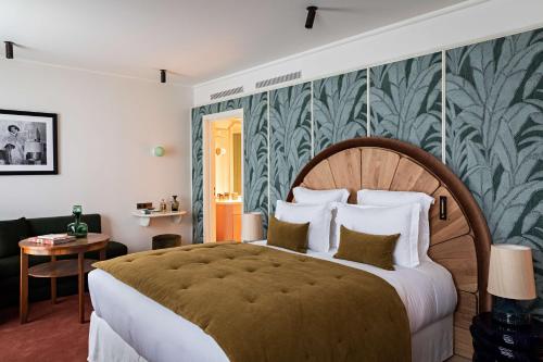 巴黎Hotel Florida Paris的一间卧室配有一张大床,拥有绿色和白色的壁纸