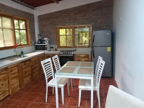 Las TunasNueva Tierra, Ayampe的厨房配有桌椅和冰箱。