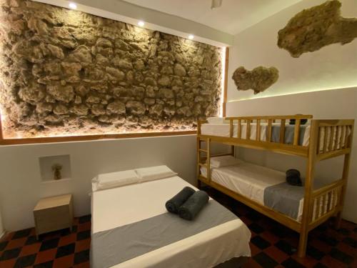 卡塔赫纳Casa Zaguan的石墙客房的两张床