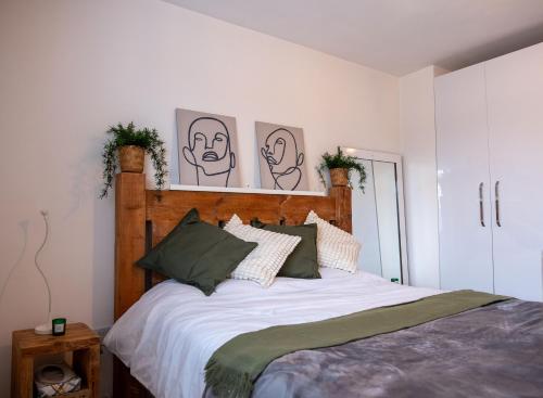 雷纳姆Lovely family home in Rainham, Kent的卧室配有一张四幅画的墙壁床。