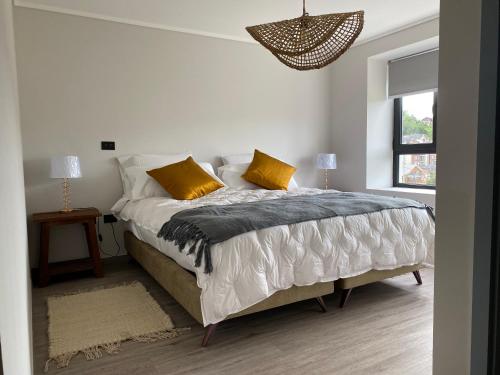巴拉斯港The Roses的白色卧室配有一张带黄色枕头的大床
