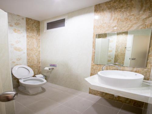 北榄坡帕塔尼酒店的一间带卫生间、水槽和镜子的浴室