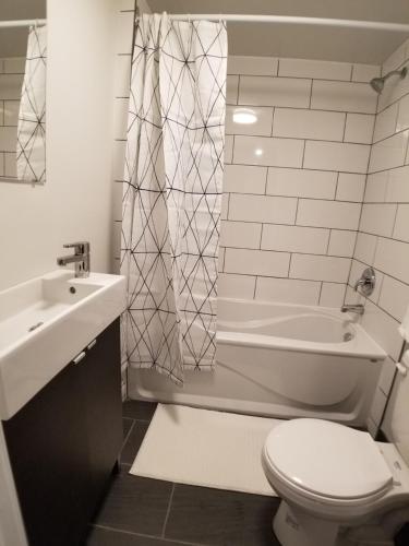蒙特利尔Modern and spacious 2 bedroom in Montreal的浴室配有卫生间、盥洗盆和淋浴。