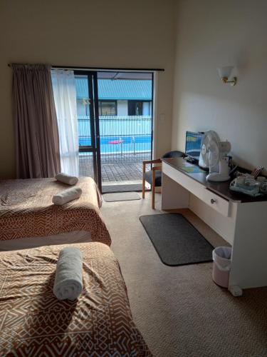 OpuaPinelodge的客房设有两张床和一张带窗户的书桌。