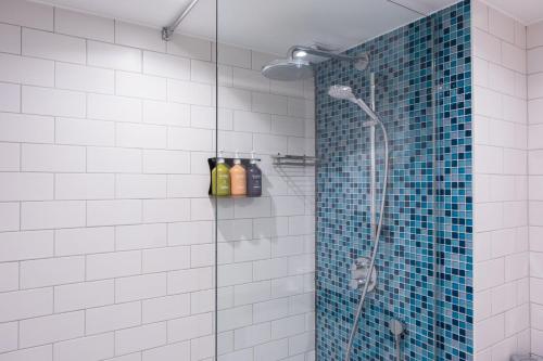 唐克斯特唐克斯特假日酒店的一间墙上装有瓶子的淋浴的浴室