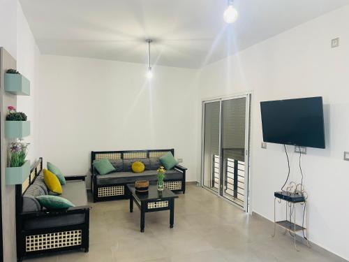 SalaktaDar Maya的带沙发和平面电视的客厅