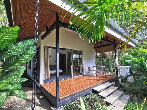 圣塔特蕾莎海滩Armadillo Eco Bungalows - Santa Teresa的房屋设有木门廊和秋千