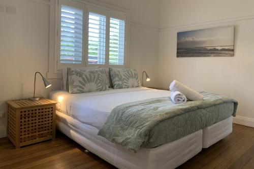 拜伦湾Byron Palms Guesthouse & Spa - Adults Only的一间卧室配有一张带两盏灯的大型白色床。
