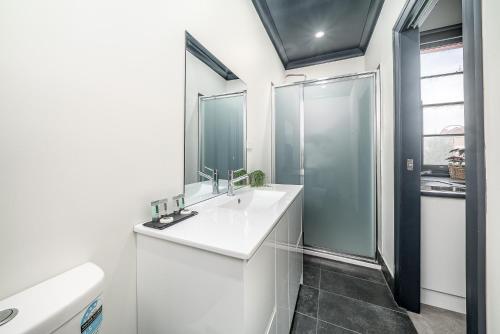 沃加沃加Romano's Hotel & Suites Wagga Wagga的白色的浴室设有水槽和淋浴。