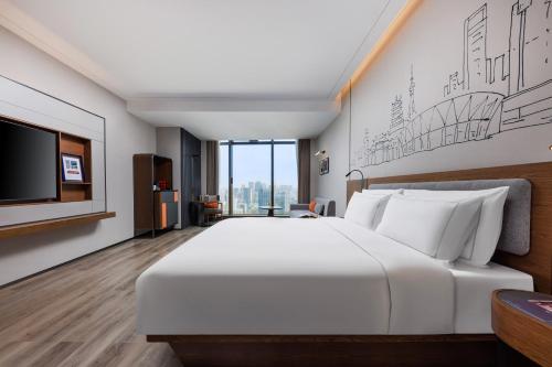 佛山佛山王府井紫薇港逸扉酒店的卧室配有一张白色大床和一台平面电视。
