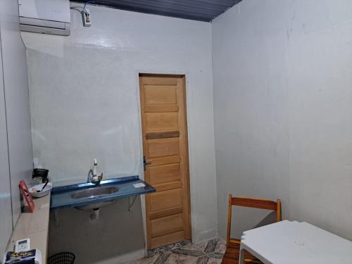 马卡帕AP 4 - Apartamento Espaçoso, Confortável e Aconchegante - Pousada Paraíso的一个带水槽和门的小厨房