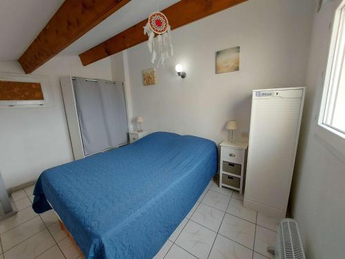 马瑟伊兰Appartement Marseillan-Plage, 2 pièces, 6 personnes - FR-1-326-798的一间卧室配有蓝色的床和冰箱