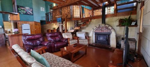 坎贝尔港东礁别墅酒店的客厅配有皮革家具和壁炉