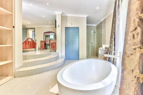 开普敦Villa Jesdene的一间位于客房内的带大型白色浴缸的浴室