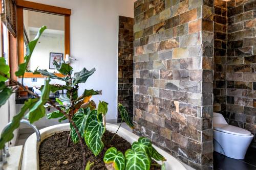 塞米亚克Melo Suites Hotel的浴室拥有砖墙和植物