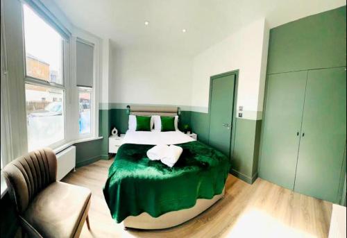 伦敦En-suite Room look like hotel的绿色和白色的卧室,配有床和椅子