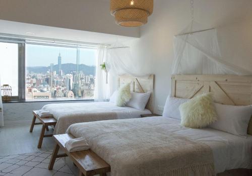 台北所在行旅-渡咕所在UrbanAbode DUGU的带大窗户的客房内的两张床