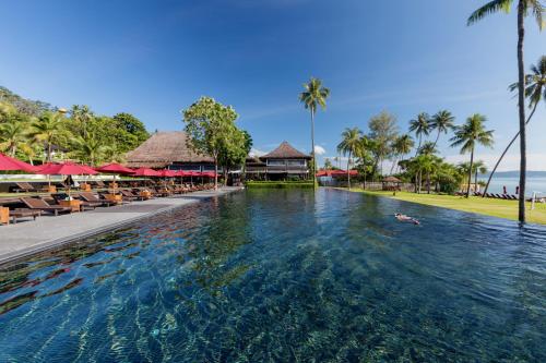 拉威海滩The Vijitt Resort Phuket - SHA Extra Plus的度假村的游泳池,人们在里面游泳