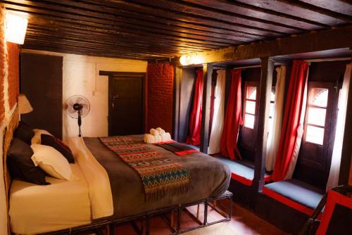 帕坦希拉宾馆的一间带床的卧室,位于带窗帘的房间