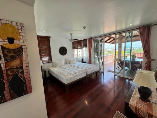 苏林海滩Surin Sabai Condo - Phuket的一间带大床的卧室和一个阳台