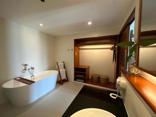 麦克坦Bluewater Maribago Beach Resort的带浴缸、卫生间和盥洗盆的浴室