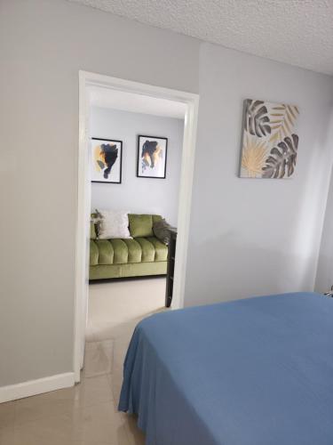 金斯敦Comfy and cozy的一间卧室配有一张床和一张绿色沙发