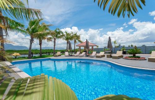 南迪Naisoso Island Villas - Fiji的一个带躺椅的游泳池,棕榈树