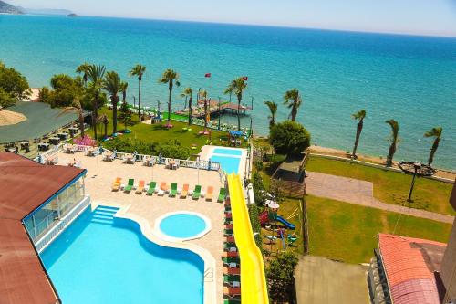 BozyazıNagidos Hotel的享有带游泳池和海洋的度假村的空中景致