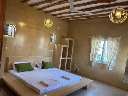 瓦塔穆Nyumbani Tamu的一间带床的卧室,位于带窗户的房间内