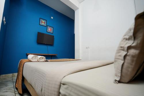 科泽科德Twinn Waves Calicut的蓝色墙壁客房的两张床