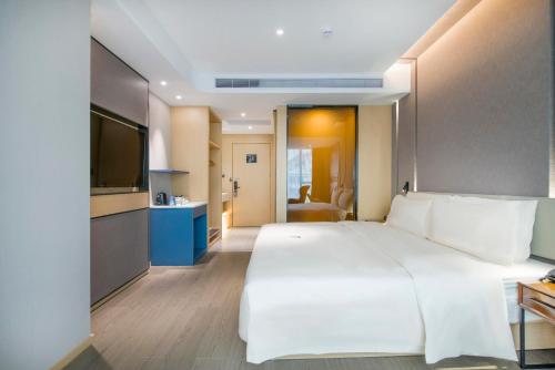 广州广州三元里亚朵酒店的卧室配有一张白色大床和电视。