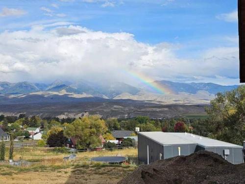 SalmonKarKens Container Home的一座带建筑物和山脉的田野上的彩虹