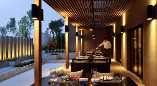 杭州杭州黄龙亚朵酒店的站在餐厅前边的男人,有桌子