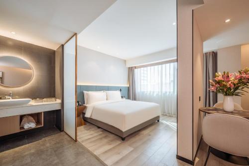 昆明昆明文化宫人民东路亚朵X酒店的一间卧室配有床、水槽和镜子
