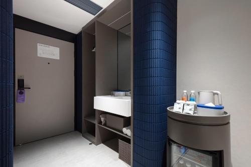 深圳深圳南山来福士广场轻居酒店的一间带水槽和镜子的浴室