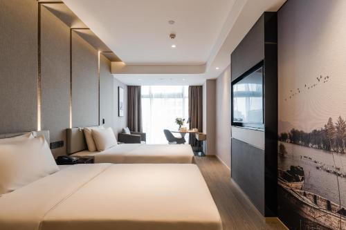 杭州杭州西湖武林广场建国北路亚朵酒店的一间酒店客房,设有两张床和电视