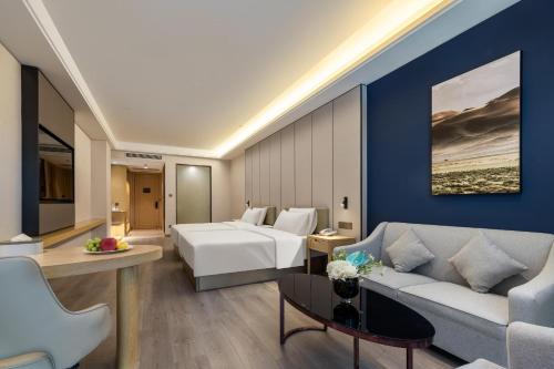 宝安深圳宝安机场航城亚朵X酒店的酒店客房,配有床和沙发