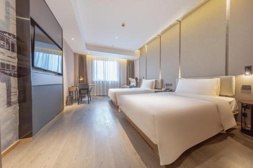 上海上海漕河泾亚朵酒店的酒店客房设有两张床和一张桌子。