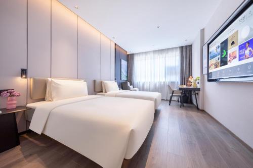 昆明昆明火车站大悦城亚朵酒店的酒店客房设有两张床和一张桌子。