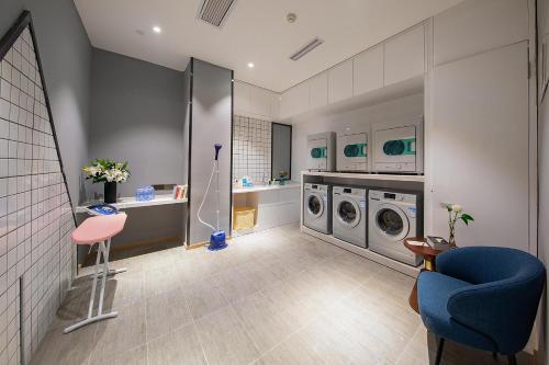 成都成都春熙路天府广场地铁站亚朵酒店的一间带两台洗衣机和蓝椅的浴室